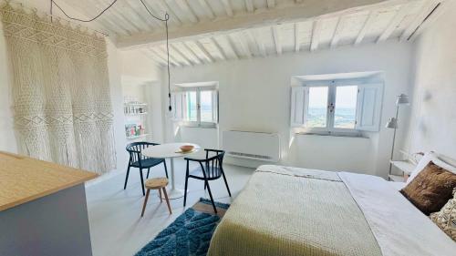 a bedroom with a bed and a table and chairs at SuSuMare in Campiglia Marittima