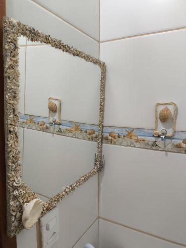 a mirror on a bathroom wall with a chain around it at Aconchego das Conchas in Mangaratiba