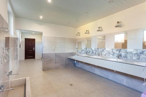 a large bathroom with two sinks and a large mirror at Przyczepa campingowa in Grzybowo