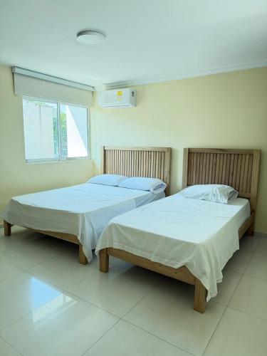 two beds sitting next to each other in a room at Apartamento amoblado Murillo in Barranquilla