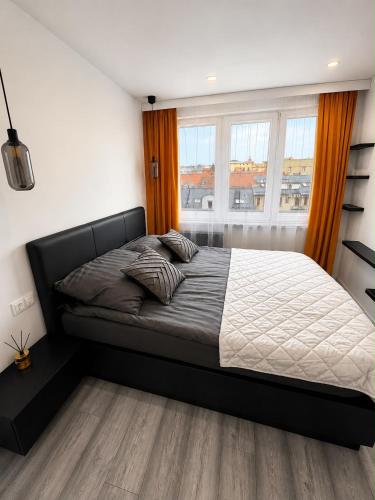 a bedroom with a bed and a large window at Exclusive Apartament Centrum 45m in Tarnów
