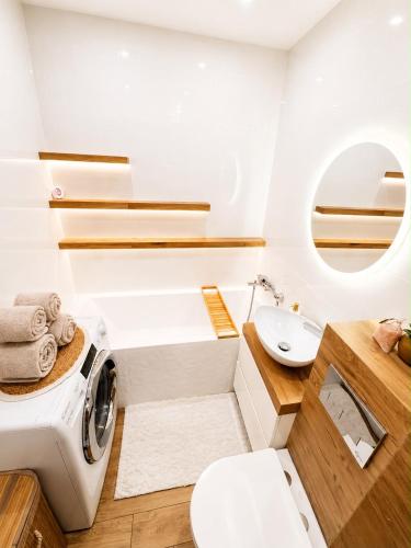 a bathroom with a washing machine and a sink at Exclusive Apartament Centrum 45m in Tarnów