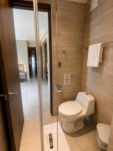 a bathroom with a toilet and a glass shower at Hotel La Leonelda in Ocaña