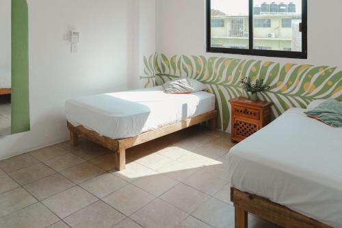 a bedroom with two beds and a couch at Casa de Rosa in Puerto Escondido