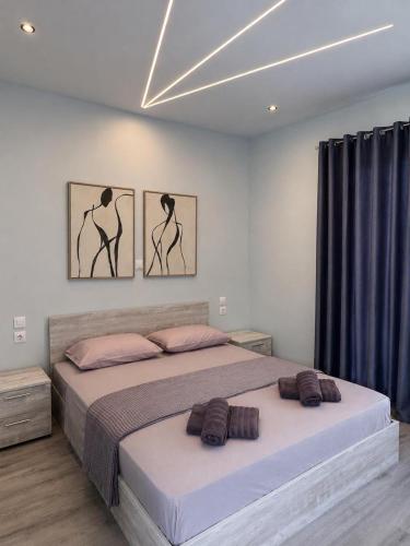 a bedroom with a bed with three pictures on the wall at Palms Guest House in Himare