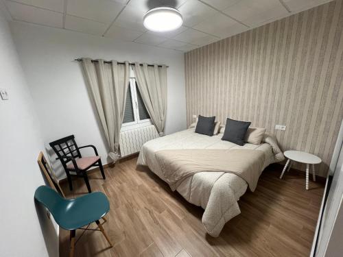 a bedroom with a bed and a chair and a window at Mirador de Molinicos in Molinicos