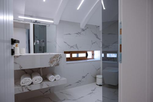 a white bathroom with a sink and a mirror at Villa 100 Boutique Pogradec in Pogradec