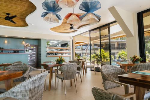 a restaurant with tables and chairs and large windows at Miamar in Manuel Antonio