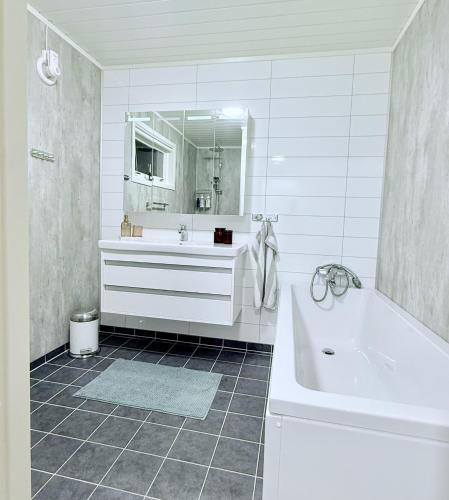 a white bathroom with a tub and a sink and a bath tub at Villa Storvoll - Fjord & Mountain View in Lyngen