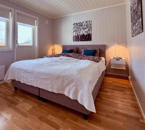 a bedroom with a large bed and a window at Villa Storvoll - Fjord & Mountain View in Lyngen