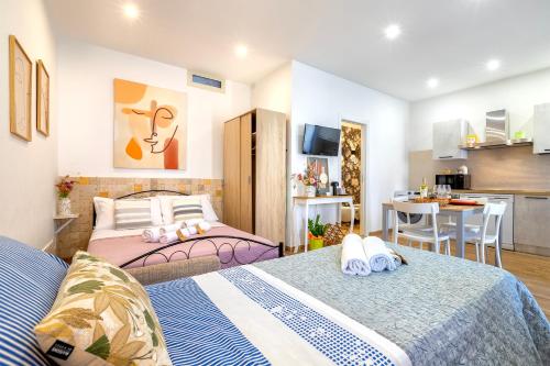 two beds in a small room with a kitchen and a kitchen at Deiana's House in Alghero