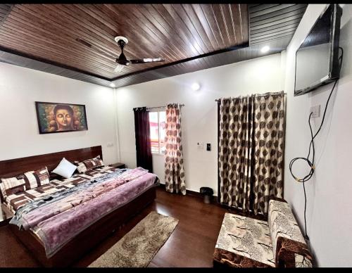 a bedroom with a bed and a tv in it at Kedar velley in Phata