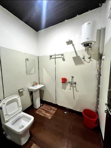 a bathroom with a toilet and a sink at Kedar velley in Phata