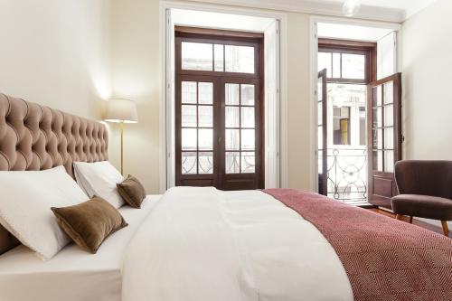 - une chambre avec un grand lit blanc et 2 fenêtres dans l'établissement Chateau Belomonte, à Porto