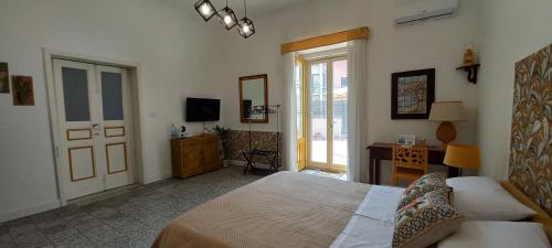 a bedroom with a bed and a desk and a door at Etna Docet in Nicolosi