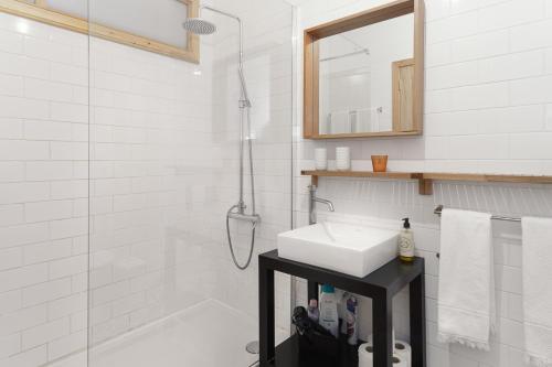 een witte badkamer met een wastafel en een douche bij Chateau Belomonte in Porto