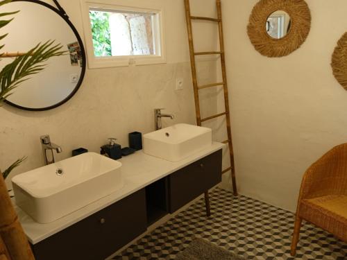a bathroom with two sinks and a mirror at Gîte de La Planette in La Romieu