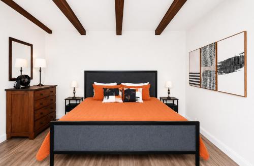 a bedroom with a large bed with an orange bedspread at Happy Harbor at Kimberling Crossing in Kimberling City