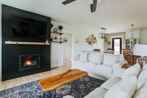 a living room with white couches and a fireplace at Afton Awaits in Afton