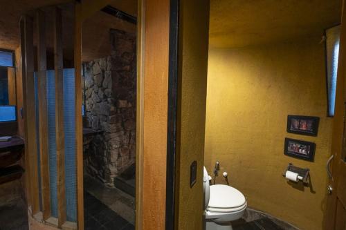 a bathroom with a toilet and a stone wall at Apart Domus in San Javier