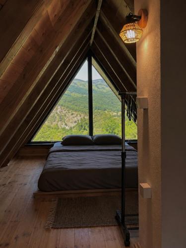 a bed in a room with a large window at Villa Vasilije in Šavnik