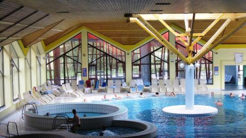 a large swimming pool with people in a building at Čebelarjeva hiška 1 - Terme Olimia - Podčetrtek in Podčetrtek