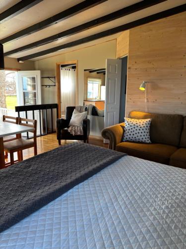 a bedroom with a bed and a living room at Hôtel-Motel Vagues Vertes in Perce