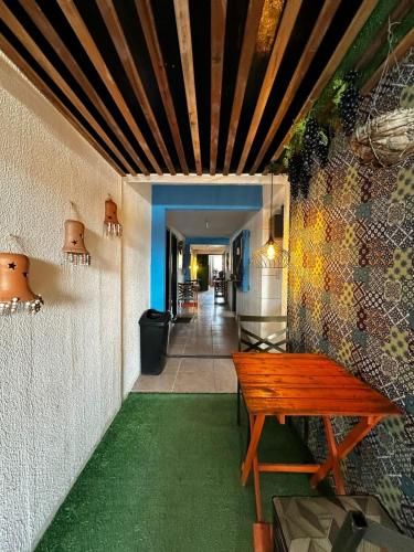 a wooden bench sitting next to a wall with a hallway at Amorim's Family Hostel in Olinda