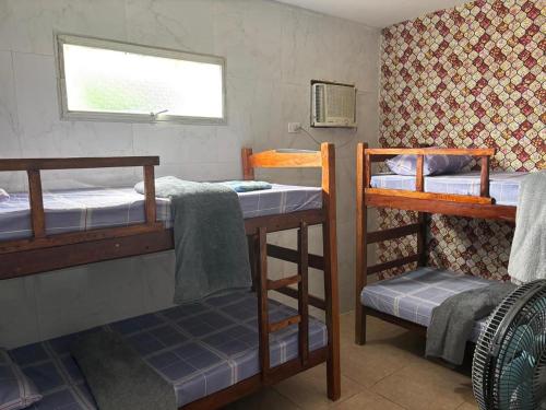 a room with two bunk beds and a window at Amorim's Family Hostel in Olinda