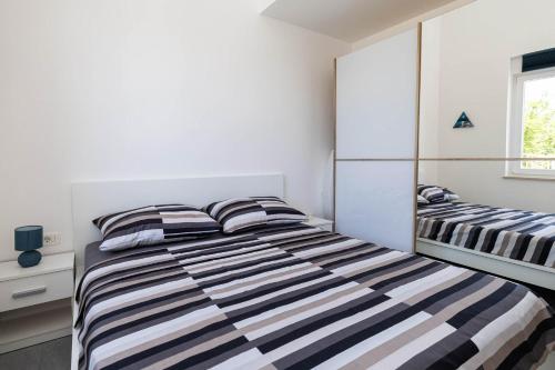a bedroom with two beds and a mirror at Apartment Panorama in Jadranovo