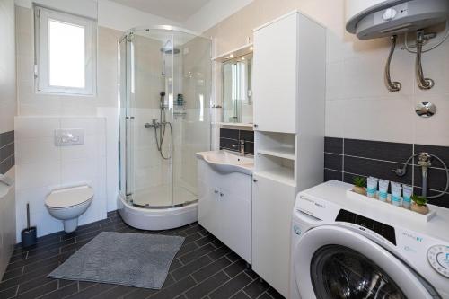 a bathroom with a washing machine and a sink at Apartment Panorama in Jadranovo