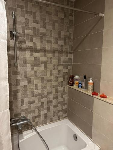 a bath tub in a bathroom with a tile wall at Zaineb in Hammamet Sud