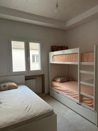 a bedroom with two bunk beds and a window at Zaineb in Hammamet Sud