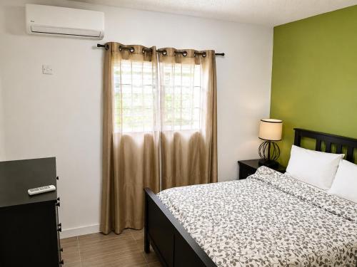 a bedroom with a bed and a window at Eden Apartments in Basseterre