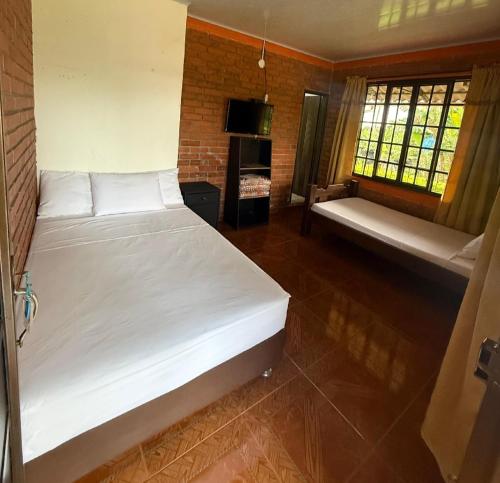 a bedroom with two beds and a couch in it at Finca Hotel Montebello in Quimbaya