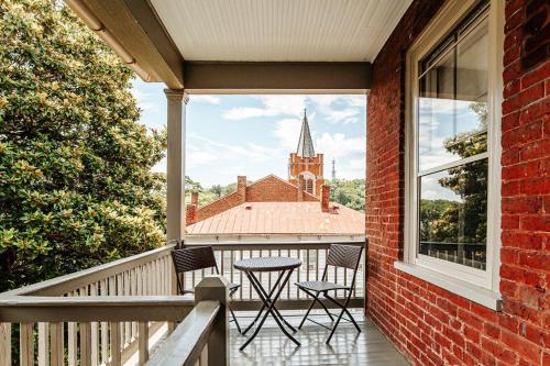 a balcony with a table and chairs and a church at Red Bud Suite in Staunton