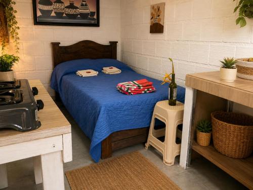 a bedroom with a bed with a blue comforter at ECOHostal Las Hamacas El Mirador A Manizales in Villamaría