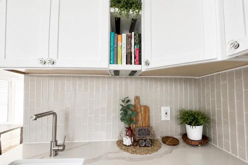 a kitchen counter with a sink and white cabinets at Lake it Easy at Kimberling Crossing in Kimberling City
