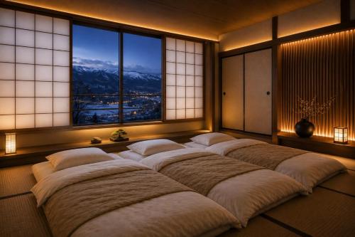 a room with four large beds in front of windows at 雪灯庵 in Iiyama