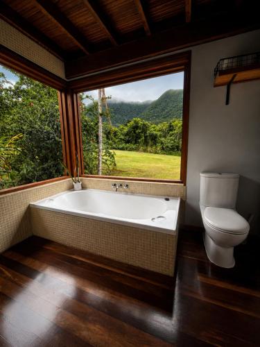 a bathroom with a tub and a toilet and a window at Cape Tribulation Getaway in Cape Tribulation