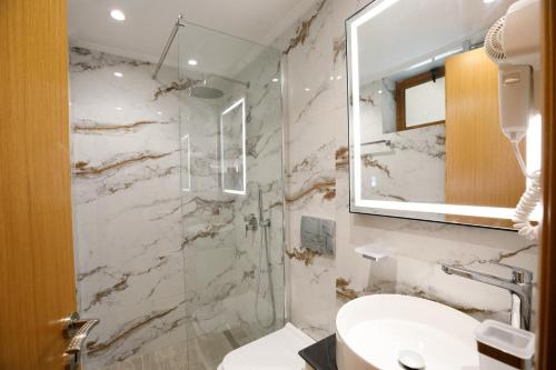 a bathroom with a toilet and a sink and a mirror at Panorama Hills Entire Villa in Gjirokastër