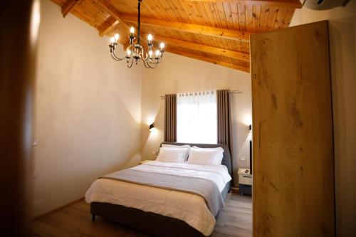 a bedroom with a bed with a chandelier and a window at Panorama Hills Entire Villa in Gjirokastër