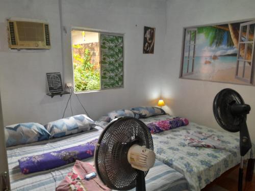 a room with two beds and a fan in it at Hospedagem Chapéu Virado in Belém