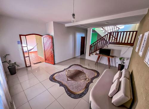 a living room with a couch and a staircase at Pousada Casa Shanti in Dourados