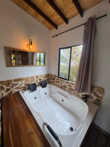 a large white tub in a room with a window at Refugio del Lago in Envigado