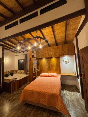 a bedroom with a bed and a bathroom with a tub at Refugio del Lago in Envigado