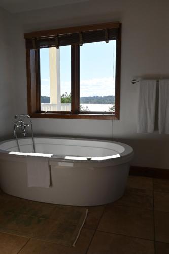 a bath tub in a bathroom with a window at Rhinecliff Hotel in Rhinecliff