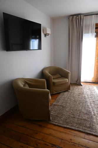 a living room with two chairs and a television at Rhinecliff Hotel in Rhinecliff