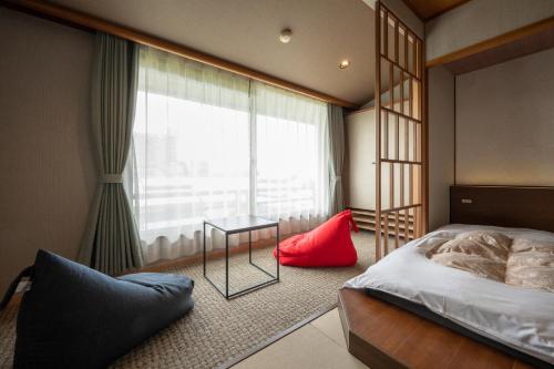 a bedroom with a bed and a large window at Awara Onsen Minoya Taiheikaku in Awara
