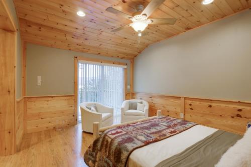 a bedroom with a bed and two chairs and a ceiling fan at Waterfront Deck + Views: Schroon Lake Sanctuary in Schroon Lake